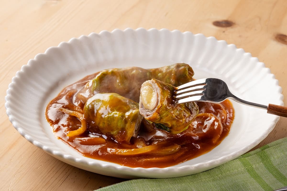 「カレーソースで食べるレタス巻き」をフォークで持ち上げている画像