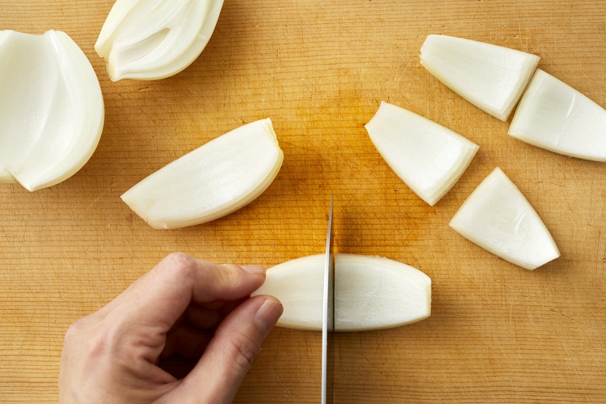 縦4等分に切った玉ねぎをさらに半分に切る様子