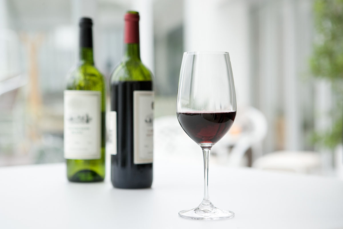 赤ワインのボトルとグラスの画像