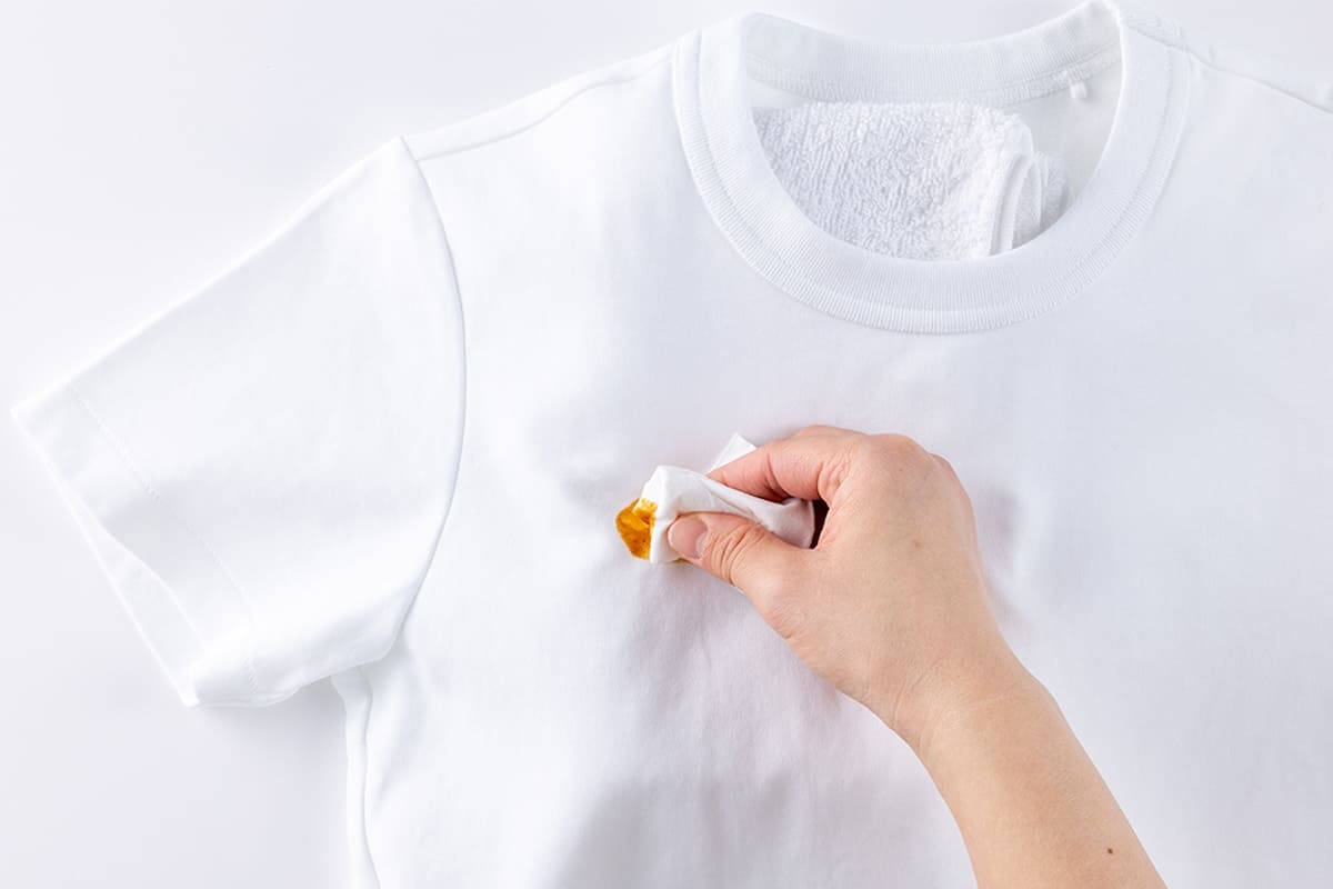 カレーの汚れをティッシュでつまみ取る様子