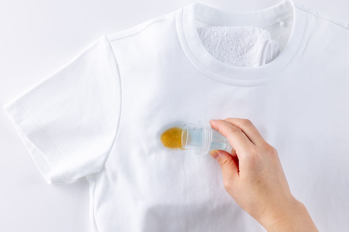 シミの部分に液体洗剤をかける様子