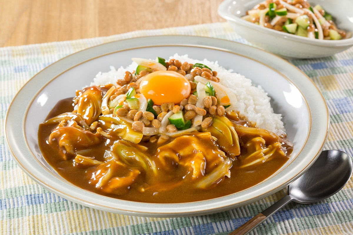 納豆と卵黄をトッピングしたカレーの写真