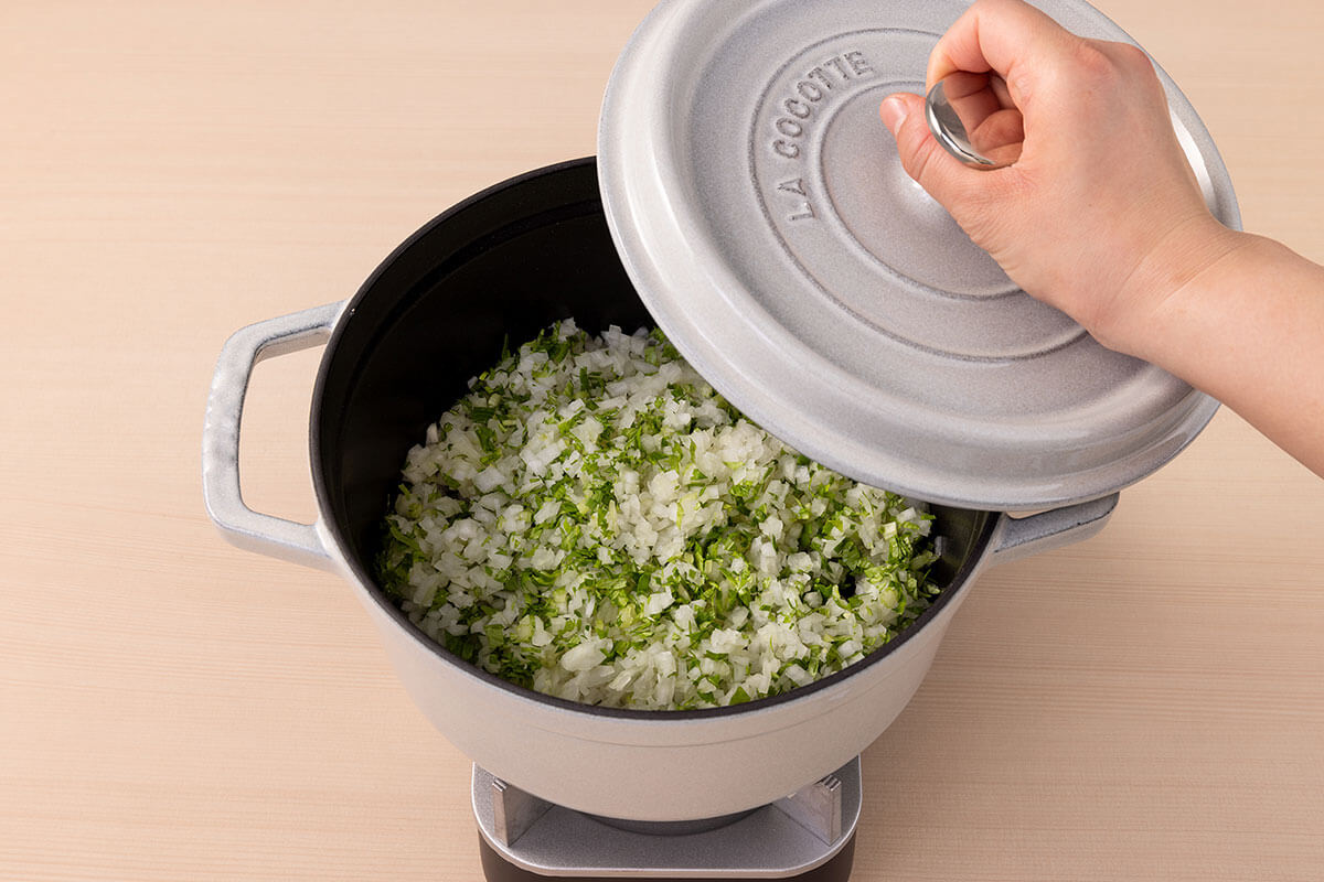 玉ねぎとセロリの葉を入れた鍋にふたをする様子